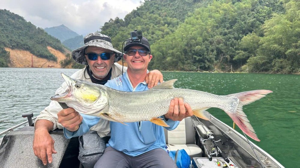 Anglers holding a Yellowcheek fish on a Vietnamese lake